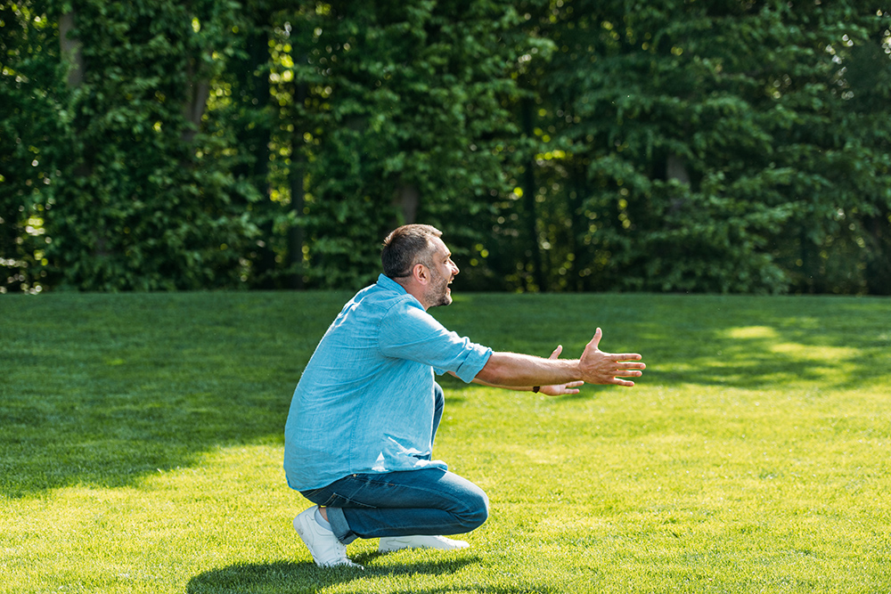 Can you kneel after knee replacement? side view of happy man with open arms crouching an 2023 11 27 05 35 03 utc Can you kneel after knee replacement?